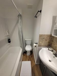een badkamer met een bad, een toilet en een wastafel bij Warm cozy 1 bdrm close to Hwy in Edmundston