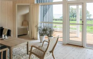 d'un salon avec une table, des chaises et une porte coulissante en verre. dans l'établissement Cozy Home In Sydals With Sauna, à Skovby