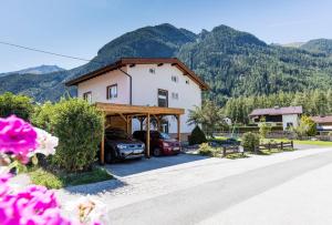 ein Haus mit zwei Autos, die in einer Einfahrt geparkt sind in der Unterkunft Haus Attos in Umhausen