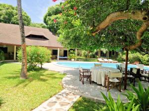 een tafel en stoelen naast een zwembad bij Giant House Malindi in Malindi