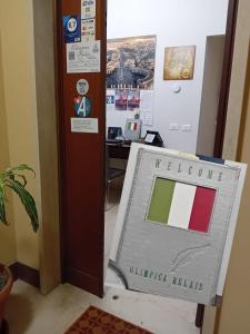 un panneau portant le drapeau de l'indonesie à côté d'un bureau dans l'établissement Olimpica Relais guest house CIR 28624, à Rome
