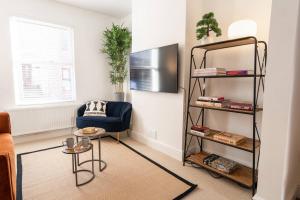a living room with a blue chair and a shelf at Stylish 3-Bed City Centre Home in Chester by 53 Degrees Property, Ideal for Groups, Private Parking! in Chester