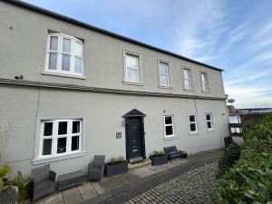 a white house with a black door and two chairs at Riverside House, North Shields Fish Quay in North Shields