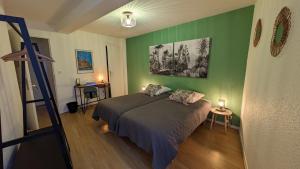 a bedroom with a bed and a green wall at La Ferme des Denis in Chanos-Curson