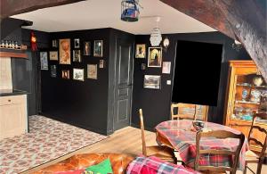 a living room with a table and a black wall at Le gîte du Sorcier 89 in Avallon