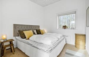 um quarto branco com uma cama grande e almofadas amarelas em Cozy Home In Aakirkeby With Kitchen em Vester Sømarken