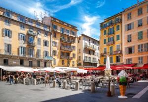 une place de la ville avec des tables, des parasols et des bâtiments dans l'établissement MAGIC CATHEDRALE, à Nice