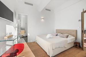 - une chambre blanche avec un lit et une table en verre dans l'établissement MAGIC CATHEDRALE, à Nice