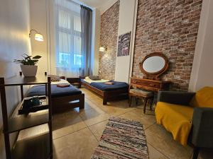 Deja Vu Hostel في وارسو: غرفة معيشة مع أريكة وجدار من الطوب