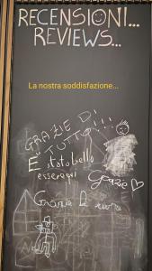 a chalkboard with writing on it with a sign on it at Nalí Guest House in Ercolano