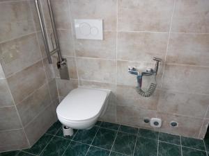 a bathroom with a toilet and a hose on the wall at Antico Borgo Del Lago Maggiore in Due Cossani