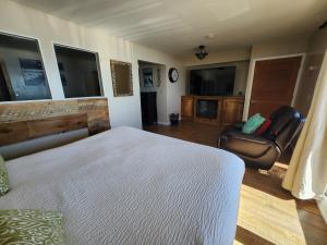 ein Schlafzimmer mit einem Bett, einem Stuhl und einem TV in der Unterkunft Inn At Avila Beach in Avila Beach