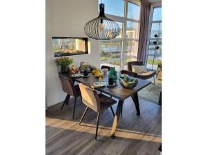 a dining room with a table and chairs and a chandelier at Holiday home Chalet 79 in Olburgen