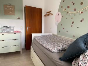 a small bedroom with a bed and a dresser with a wall at Ferienwohnung Dorfblick mit 2 SZ, Balkon und Ski- oder eBike Keller in Winterberg