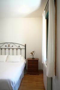 a bedroom with a bed and a dresser and a window at Casa Videira - Hotel rural cerca del mar in Bueu