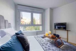 1 dormitorio con 1 cama con bandeja de comida y TV en 20 m² métro 7 à 5 min à pied, en Le Kremlin-Bicêtre