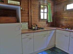 een keuken met witte kasten en een witte koelkast bij Bed & Happiness in Wichmond