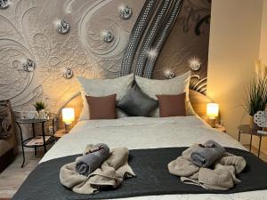 a bedroom with a bed with towels on it at Oreo Apartman in Eger +42 photos