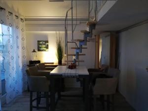 a dining room with a table and chairs and a staircase at Holiday apartment boathouse in Stavoren
