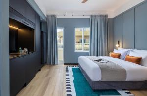 a bedroom with a large bed and a kitchen at Albi Florentin in Tel Aviv