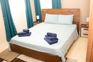 um quarto com uma cama com toalhas azuis em Blossoms Apartment em San Ġwann