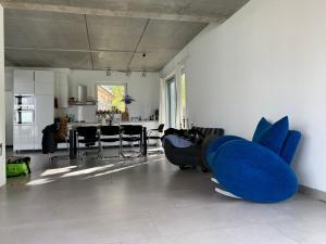 a living room with a blue couch and a kitchen at A cozy room in a modern House in Potsdam