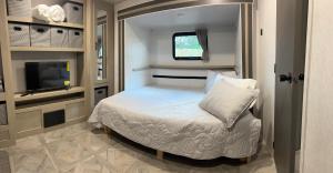 - une petite chambre avec un lit et une télévision dans l'établissement Homestead RV, à Homestead
