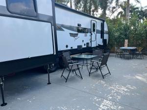 ein Wohnwagen mit Tisch und Stühlen und ein Schild in der Unterkunft Homestead RV in Homestead