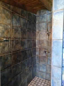 a bathroom with a shower with a tiled wall at Casa Mosaico, sunset and garden in Los Llanos de Aridane +26 photos