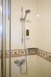 a shower with a shower head in a bathroom at Casa Videira - Hotel rural cerca del mar in Bueu