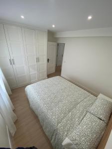 ein weißes Schlafzimmer mit einem Bett und weißen Schränken in der Unterkunft Espacioso Apartamento Familiar en Aranjuez - Confort, Tranquilidad y Netflix Incluido in Aranjuez