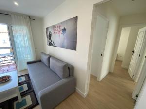 ein Wohnzimmer mit einem Sofa und einem Tisch in der Unterkunft Espacioso Apartamento Familiar en Aranjuez - Confort, Tranquilidad y Netflix Incluido in Aranjuez