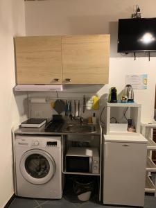 uma cozinha com um lavatório e uma máquina de lavar roupa em Monolocali del Montecontessa by SMART-HOME 