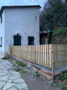 uma cerca de madeira em frente a uma casa branca em Monolocali del Montecontessa by SMART-HOME 
