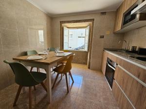 - une cuisine avec une table et des chaises en bois dans la chambre dans l'établissement Carmen House - Laxe - Costa da Morte, à Laxe 9 autres photos