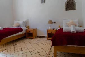 1 dormitorio con 2 camas y 2 mesitas de noche en Dar Ait Bouguemez en Azilal