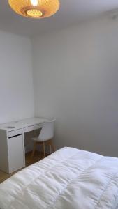 - une chambre avec un bureau et un lit avec une chaise dans l'établissement La Boissière, à Avrillé