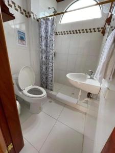 a bathroom with a toilet and a sink at Hostal Muro De Las Lagrimas with high speed internet Starlink in Puerto Villamil