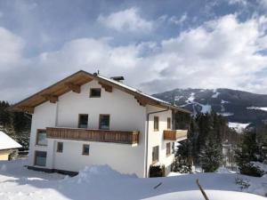 a house in the snow with mountains in the background at Chalet zum Wohlfühlen in Ramsau am Dachstein