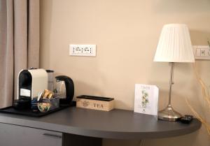 a table with a coffee maker and a lamp on it at Pae veciu camera privata con bagno in Monterosso al Mare