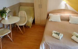 ein kleines Zimmer mit einem Bett, einem Tisch und einem Tisch in der Unterkunft Rooms & Apartments Villa Anka in Tučepi