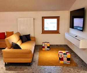 un soggiorno con divano e TV di Al Glicine Apartments a Lazise