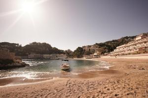 una barca in acqua su una spiaggia di Mazzarò Luxury Apartment Taormina a Taormina