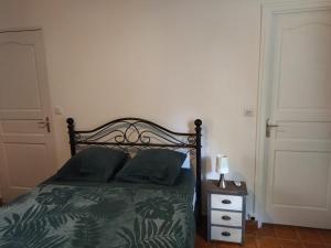 1 dormitorio con 1 cama con sábanas verdes y mesita de noche en casa DOM, en Le Robert