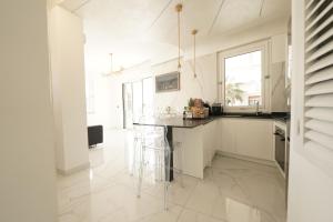 a white kitchen with a counter and a sink at Mazzarò Luxury Apartment Taormina in Taormina