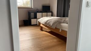 a bedroom with a bed and a desk with a television at A cozy room in a modern House in Potsdam