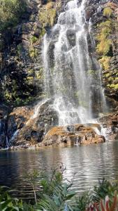 una cascata sopra uno stagno di fronte a un corpo idrico di Pousada Serra Morena a Serra do Cipo