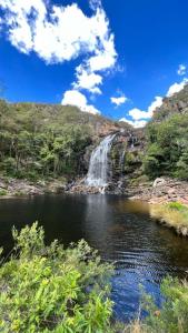 a waterfall and a pool of water in a river at Pousada Serra Morena in Serra do Cipo