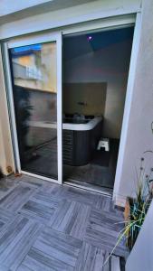 ein Badezimmer mit einer großen Glasschiebetür und einem Waschbecken in der Unterkunft Loft 100 M2 Marseille 4 ème avec jacuzzi in Marseille