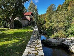 a stone bridge over a river next to a house at Izeria 112 Riverside House in Piechowice
